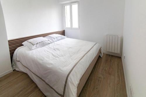 une chambre avec un grand lit blanc avec une fenêtre dans l'établissement Suprenant T2 entièrement refait avec gout, à Marseille