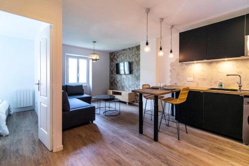 une cuisine et un salon avec une table et un canapé dans l'établissement Suprenant T2 entièrement refait avec gout, à Marseille
