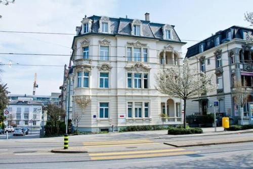 a large white building on the corner of a street at Renovated Apartment Near Zurich Lake Sees - Self Checkin in Zürich