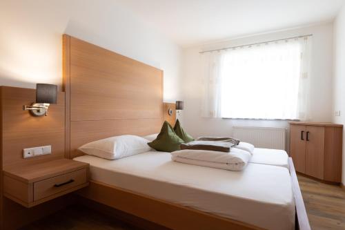 a bedroom with a large bed with a wooden headboard at Residence Walchhof in Schenna