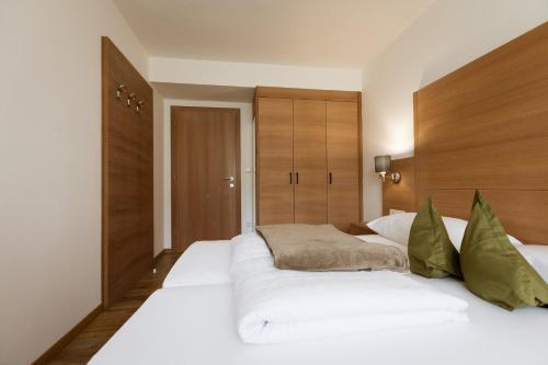 a large white bed in a room with wooden cabinets at Residence Walchhof in Schenna