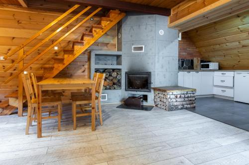 a dining room with a table and a fireplace at WIATR Apartamenty Mazurska Kraina Narie in Bogaczewo