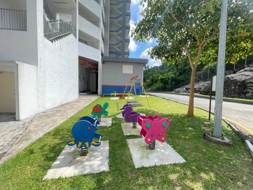a playground with three dinosaurs on the grass at kkLee Homestay Condo Taiping A-4-6 in Taiping