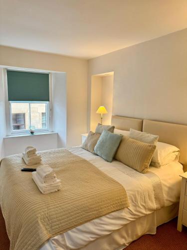 a bedroom with a large bed with towels on it at Pebbles Cottage in Cellardyke