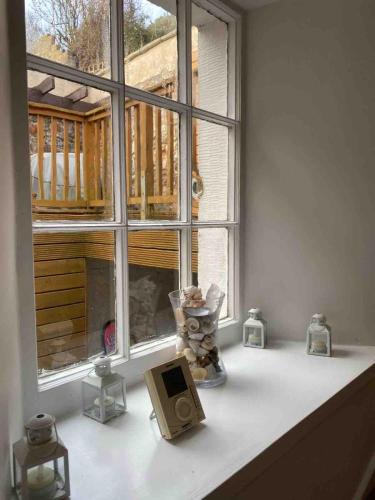 a window sill with candles and a computer on it at Pebbles Cottage in Cellardyke