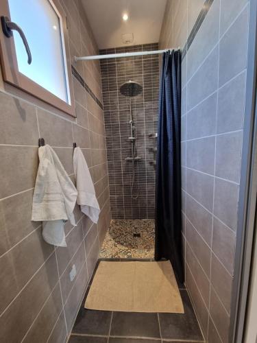 a bathroom with a shower with a shower curtain at Jolie maison avec jardin et pergola in Hastingues