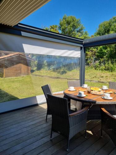 un patio avec une table et des chaises sur une terrasse dans l'établissement Jolie maison avec jardin et pergola, à Hastingues