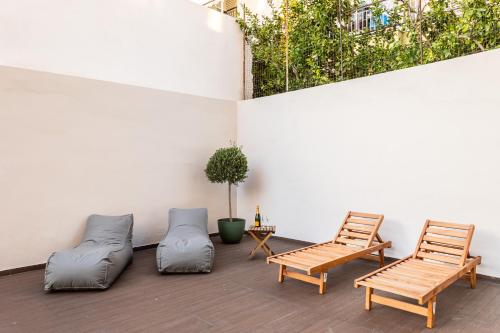 two chairs and a couch on a patio at Grec Suites Dafni, Athens by GrecCollection in Athens