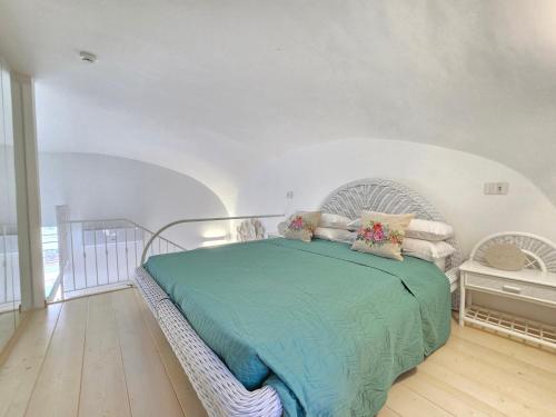 a bedroom with a bed with a green comforter at Grazy Home - Bright new Apt with Terrace and Jacuzzi in Vico Equense