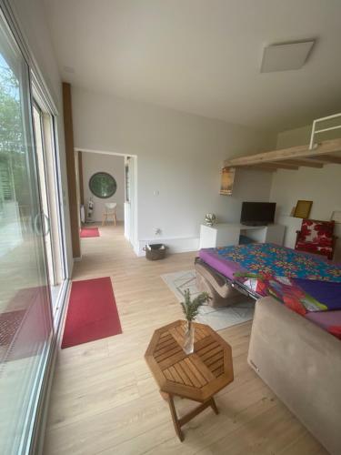 une chambre avec un lit et un salon dans l'établissement La maison sous le noyer, à Montessut