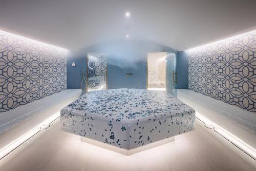 a bedroom with a bed in a room with blue walls at Grand Hotel Villa Serbelloni - A Legendary Hotel in Bellagio
