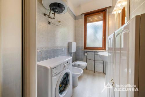 a bathroom with a washing machine and a toilet at Darina - Immobiliare Azzurra in Lazise