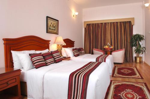 a hotel room with two beds and a window at Gulf Gate Hotel in Manama