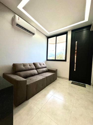 a living room with a couch and a window at Flats Luxo - Apartamentos 2 Quartos com Garagem in Palmas