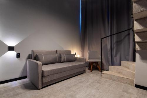 a living room with a couch and a staircase at TOLIVE One Housi Recife by Carpediem in Recife