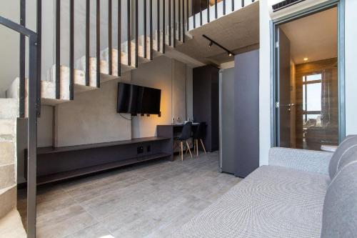 a living room with a tv and a staircase at TOLIVE One Housi Recife by Carpediem in Recife