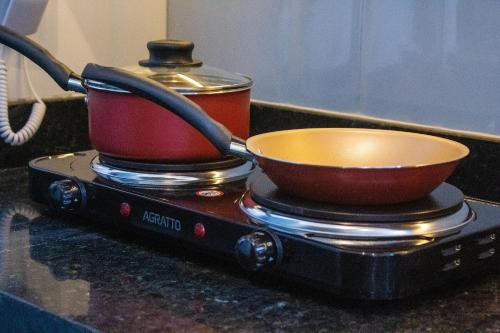 a tea pot and a bowl on a stove at TOLIVE One Housi Recife by Carpediem in Recife