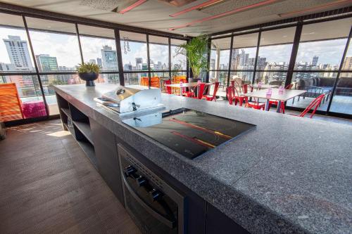 a kitchen with a counter with a view of the city at TOLIVE One Housi Recife by Carpediem in Recife