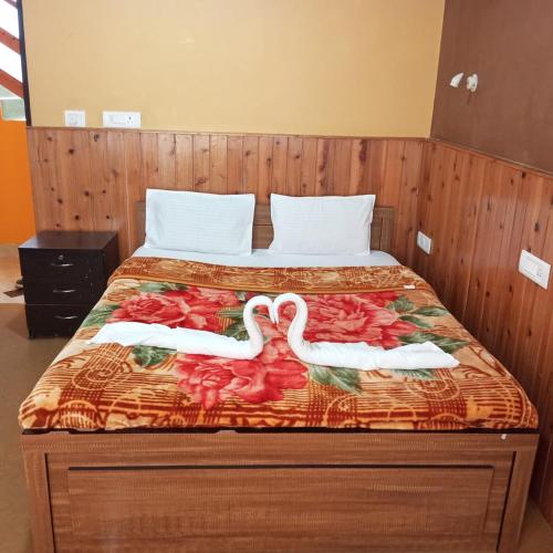 a bed with two swans on it at Hotel Happy Home in Ravangla