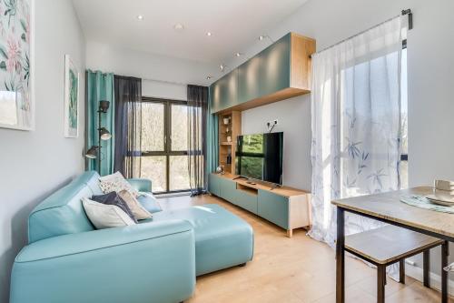 a living room with a blue couch and a table at City Line Apartment 2 in Newtownabbey