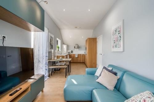 a living room with a blue couch and a kitchen at City Line Apartment 2 in Newtownabbey