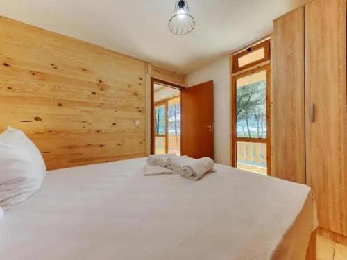 a bedroom with a large white bed with wooden walls at Imperial Family Bungalows in Ulcinj