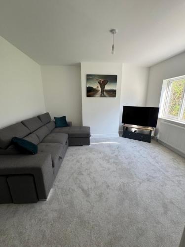 a living room with a couch and a flat screen tv at 3 bedroom Home in chesterfield with front and back gardens in Chesterfield