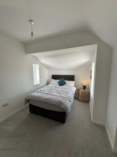 a bedroom with a large bed in a white room at 3 bedroom Home in chesterfield with front and back gardens in Chesterfield