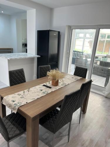 a dining room table with chairs and a kitchen at 3 bedroom Home in chesterfield with front and back gardens in Chesterfield