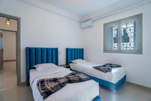 a bedroom with two beds and a window at Dream Garden Djerba in Djerba