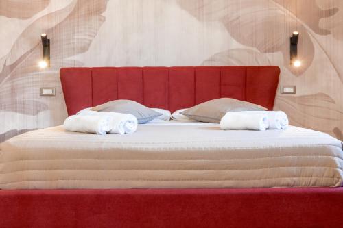 a red bed with two towels on top of it at Domus Angeli in Assisi