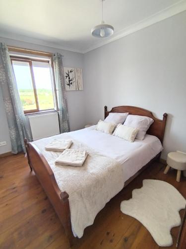 une chambre avec un lit avec des draps blancs et une fenêtre dans l'établissement Le clos de bourdeilles chambre 3 avec wifi, à Bourdeilles