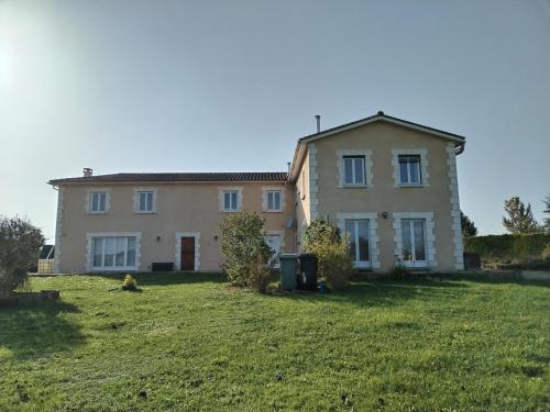 une grande maison avec une cour herbeuse devant elle dans l'établissement Le clos de bourdeilles chambre 3 avec wifi, à Bourdeilles
