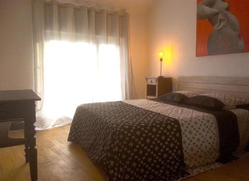 - une chambre avec un lit en face d'une fenêtre dans l'établissement La maison de vacances, à Lalizolle