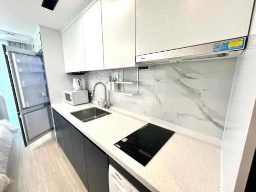 a white kitchen with a sink and a microwave at THE DECEMBER STAY Busan Songdo Ocean Terrace in Busan