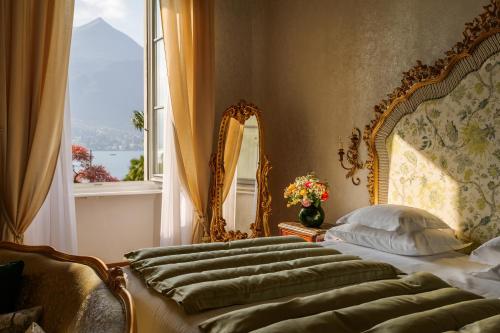 a bedroom with a bed with a large window at Grand Hotel Villa Serbelloni - A Legendary Hotel in Bellagio