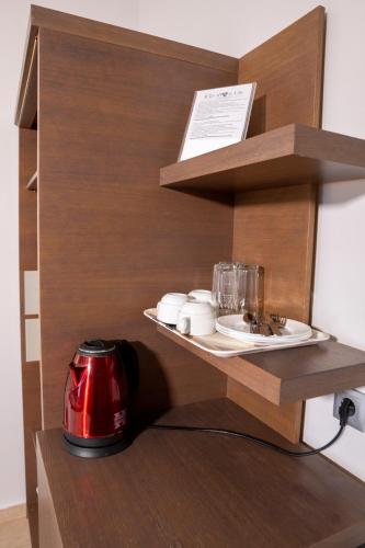 a kitchen with a toaster and dishes on a shelf at Hotel Epavlis Eleftheriadi in Paralia Katerinis