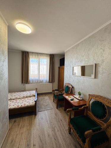 a room with a bed and a table and chairs at Hostel „La Galan” in Rădăuţi
