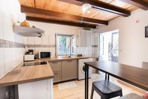 une cuisine avec des armoires blanches et une table en bois dans l'établissement Chez Marla, à Évisa