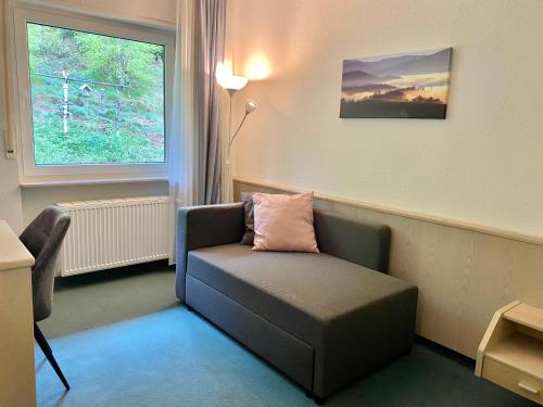 a living room with a chair and a window at Hotel Wanderlust B&B in Gernsbach