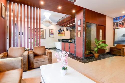 a living room with two chairs and a table at Townhouse OAK Nilay Residency in Bhubaneshwar