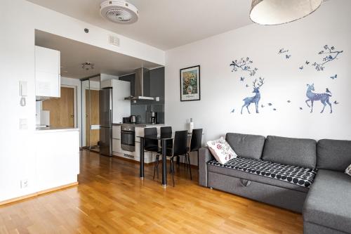 a living room with a couch and a kitchen at Hervanta Heat Loft - Ilmainen WIFI in Tampere
