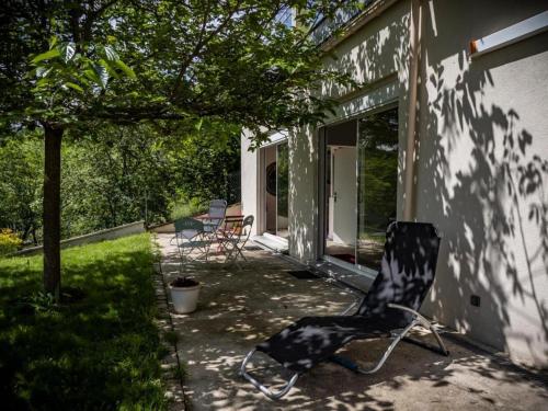 una silla blanca y negra sentada fuera de una casa en Maison sous le noyer, en Montessut