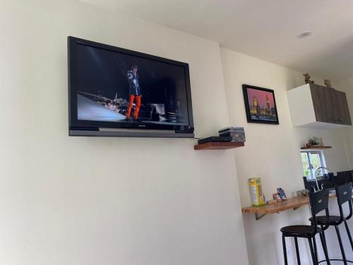 a flat screen tv hanging on a wall at Cabaña Morada Rachusiju para relajarte y descansar in Tabio