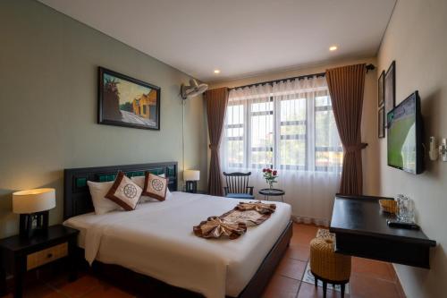 a bedroom with a large bed and a desk and window at Khoi Nguyen Villa in An Bang