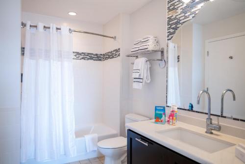 a white bathroom with a sink and a toilet at Meliá Orlando Celebration in Orlando