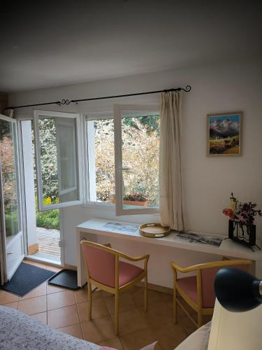 une pièce avec une table, des chaises et une fenêtre dans l'établissement Chambre Studette indépendante, à Briançon