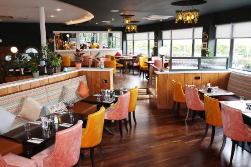 a restaurant with tables and chairs and a bar at Great National South Court Hotel in Limerick