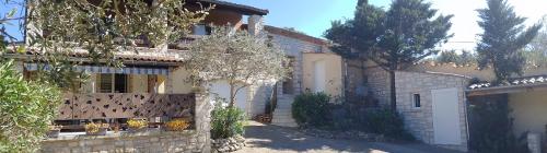 a house with a stone fence in front of it at Les Lauriers Roses in Salavas