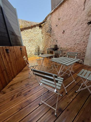 a group of chairs and tables on a wooden deck at Au Petit Langres Logement Centre-Ville in Langres
